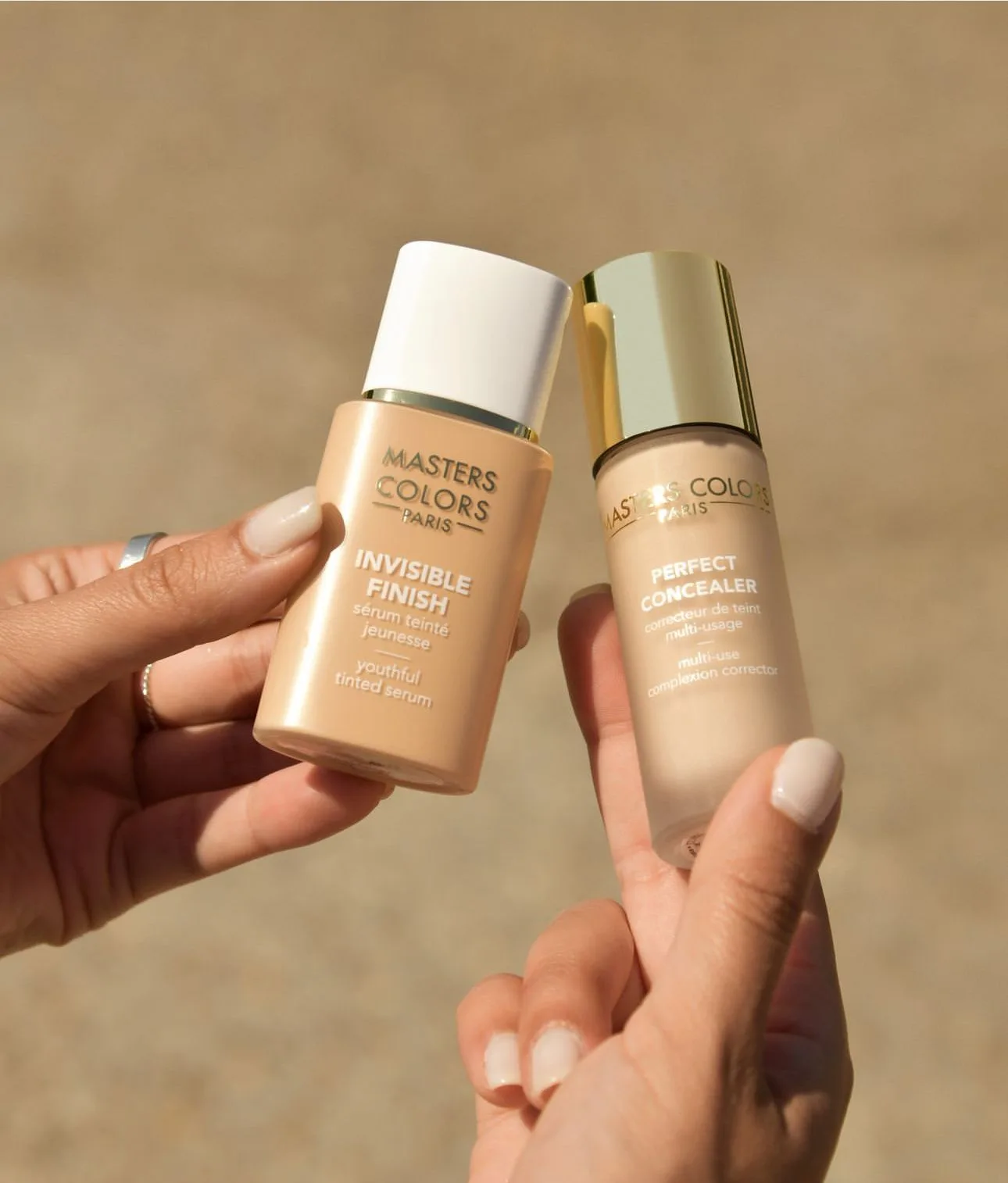 Zwei Foundations von Masters Colors in der Hand