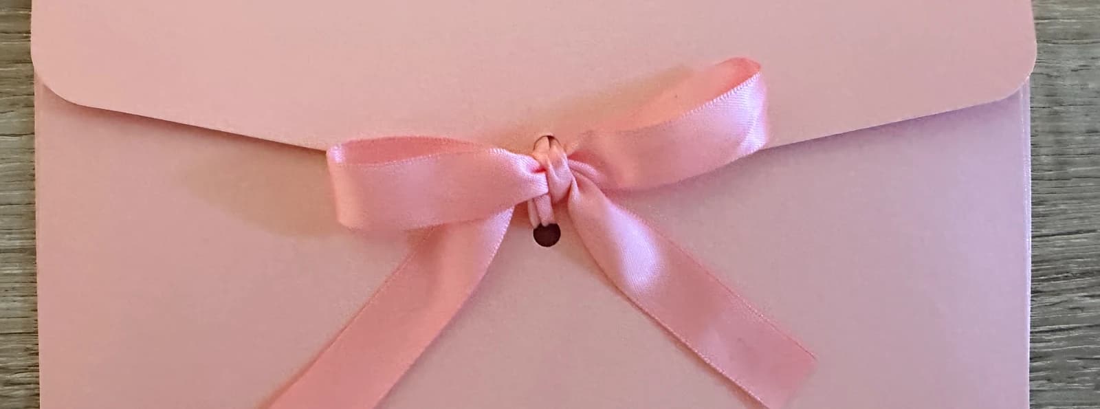 Verpackter Geschenkgutschein mit Satinschleife